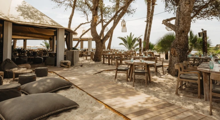 beach-restaurant-santa-eulalia-ibiza Beachfront restaurant with wooden tables and lounge area on the sand in Santa Eulalia Ibiza near the jet ski center jetski.club