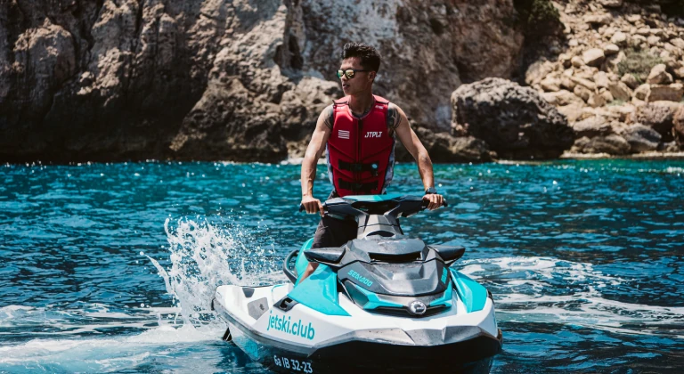 Man riding a Sea-Doo jet ski during a guided jet ski tour with jetski.club in Ibiza turquoise waters