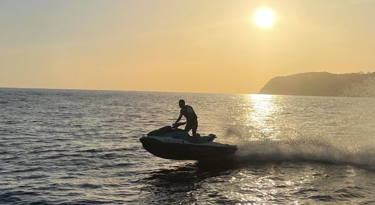 jet-ski-sunset-ibiza-jetskiclub Jet ski rider at sunset on the Mediterranean Sea during a jetski.club tour in Ibiza