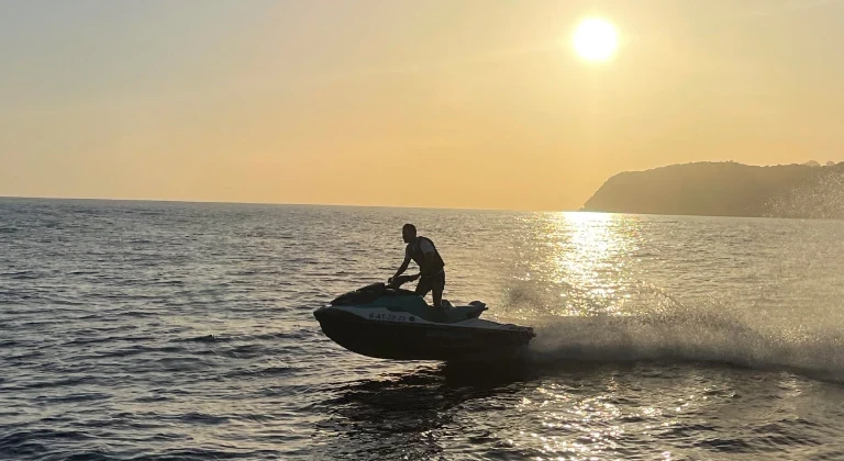 Jet ski rider speeding across the Mediterranean Sea at sunset during a guided jetski.club tour in Ibiza