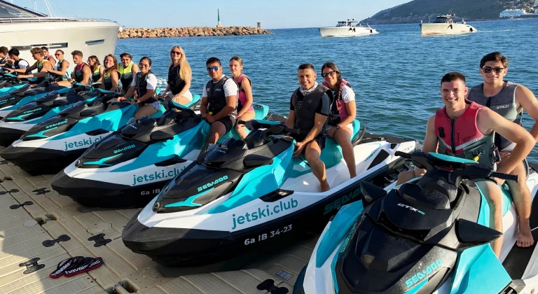 jetski-incentive-group-ibiza-jetskiclub-bright Corporate incentive group sitting on Sea-Doo jet skis at jetski.club platform in Marina Santa Eulalia Ibiza before starting a guided jet ski tour