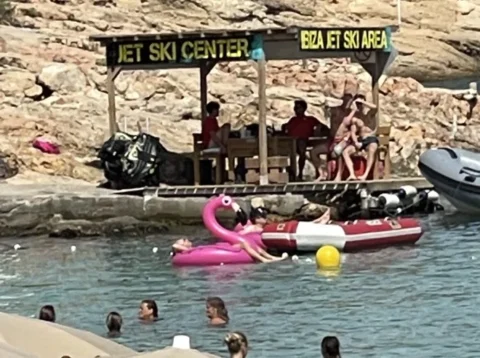 Jet ski booking hut on Cala Bassa beach Ibiza with clients preparing for jet ski tour