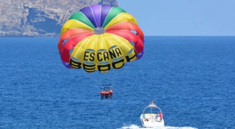 Parasailing in Ibiza with panoramic coastline views from a boat