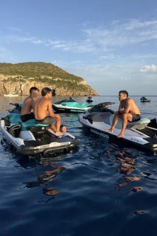 Guests relaxing around jet skis near Tagomago Island during a Sunset Jet-Ski Tour in Ibiza
