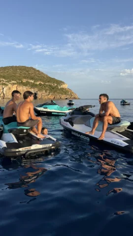 Jet skis floating in front of Tagomago Island at sunset in Ibiza